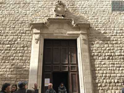 Il portale in legno, decorato con motivi geometrici, � racchiuso in una cornice sovrastata dallo stemma stellato dell'ordine dei carmelitani
